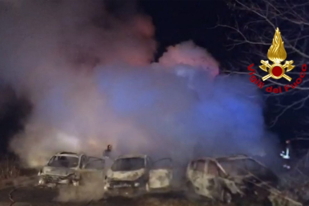 This image grabbed from a video taken and handout on January 29, 2020 by the Italian Department of firefighters, the Vigili del Fuoco, shows rescuers intervening after criminals attempted to ambush an armoured truck on a stretch of highway between Milan and Lodi, in San Zenone al Lambro. - Several burning vehicles on a highway in northern Italy were set up to stop an armored truck carrying cash, but the truck's driver managed to drive through the wall of fire and escape. The attack occurred shortly before midnight late on January 28, 2020, as criminals set fire to about ten vehicles, all probably stolen, in both directions of travel on the motorway. (Photo by Handout / Vigili del Fuoco / AFP) / RESTRICTED TO EDITORIAL USE - MANDATORY CREDIT 